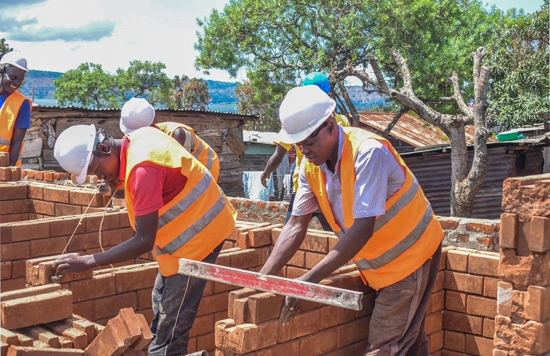 Masons building brick walls for a new house in Kenya